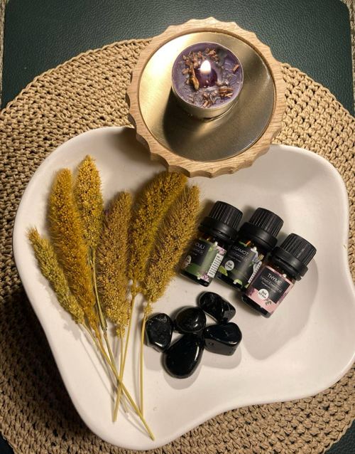 Ritual-Setting mit Trockenblumen, Duftölen und Kerze